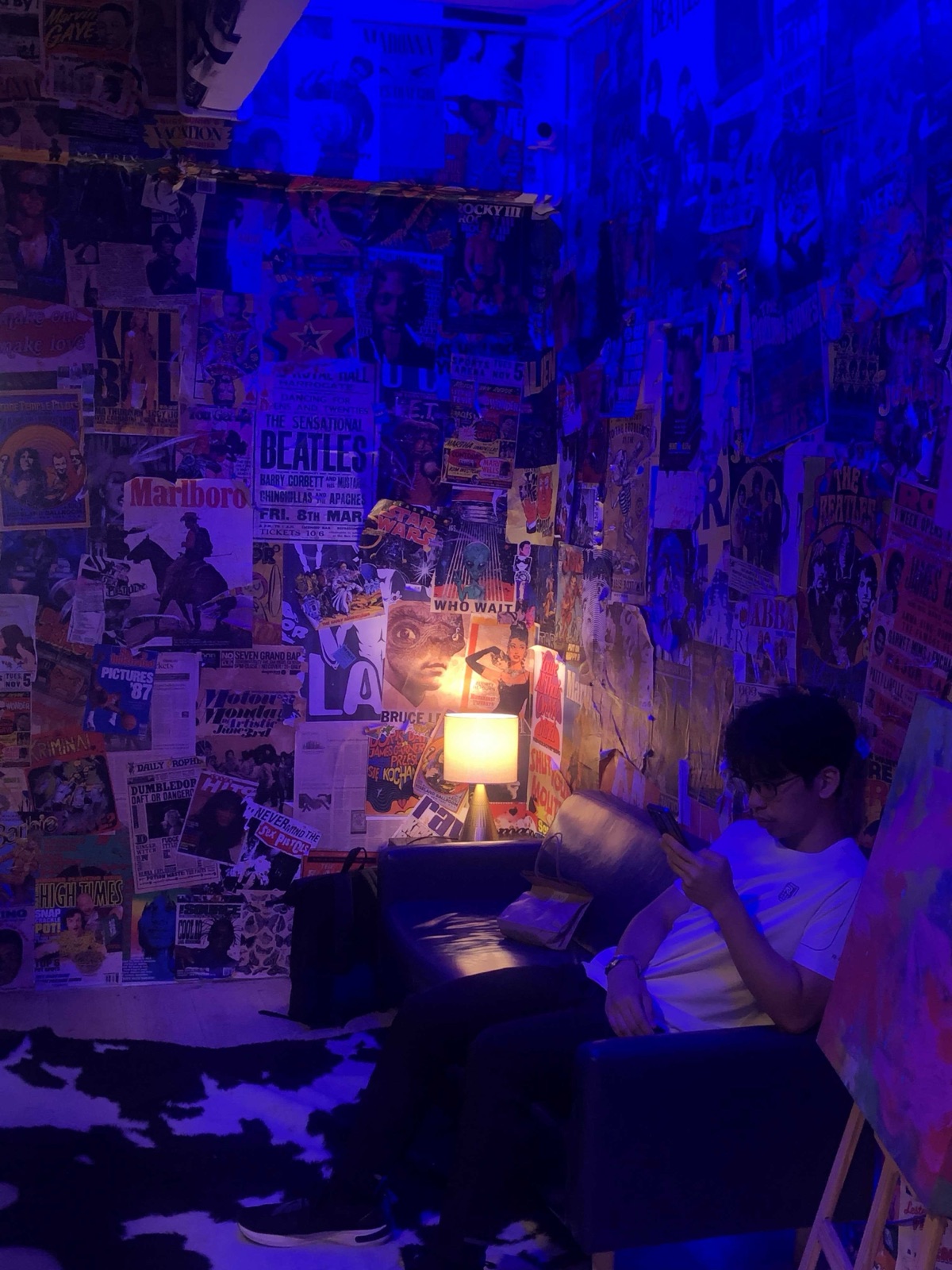 Leonard Su sitting in a dimly lit room with music posters